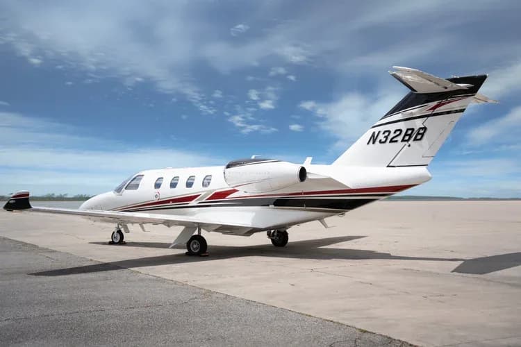 Cessna Citation M2 aircraft on the ground, rear side view.
