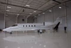 Learjet parked inside a hangar with a shiny floor.