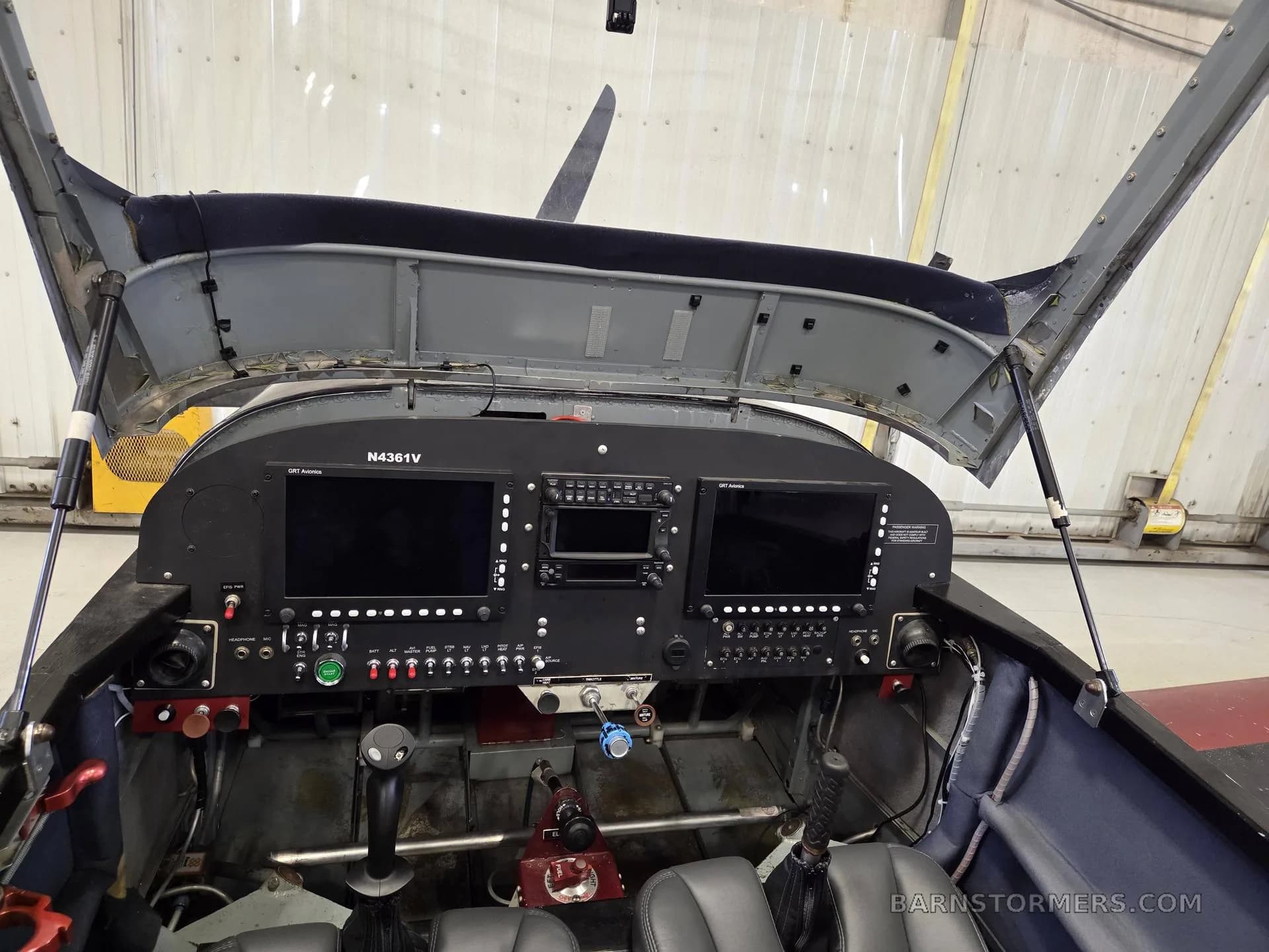The cockpit of an N4361V aircraft with the canopy open, showing the instrument panel with two blank screens.