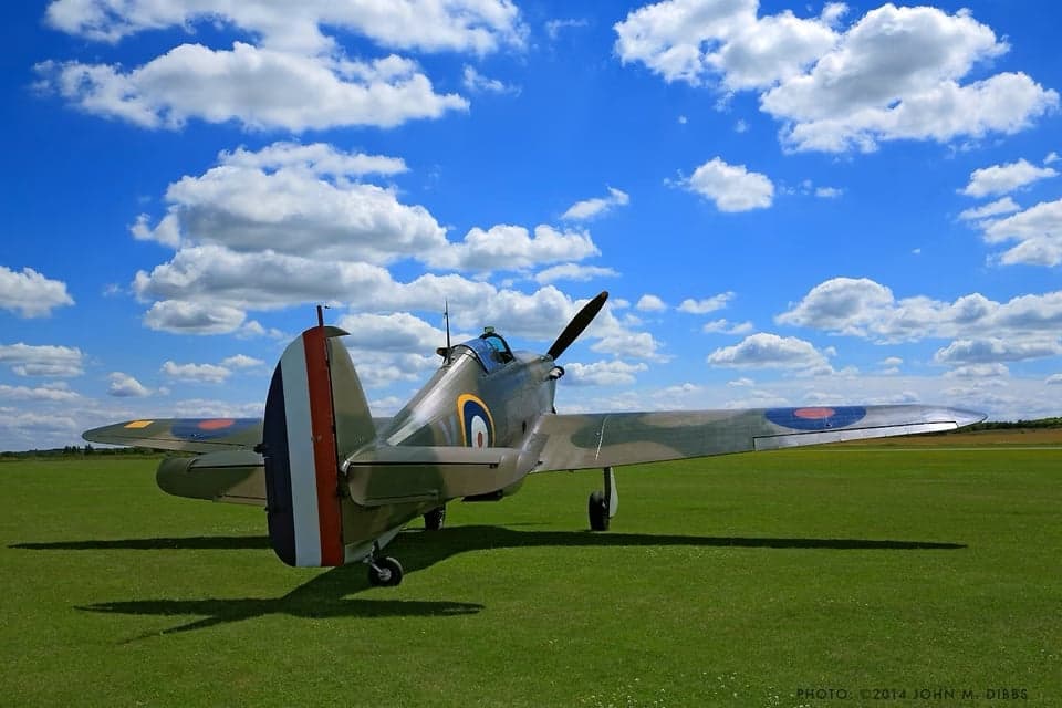 Hawker Hurricane fighter in flight over the ocean near white cliffs.