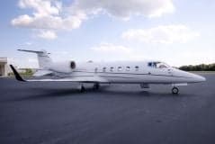 Side view of a white Learjet on the tarmac.