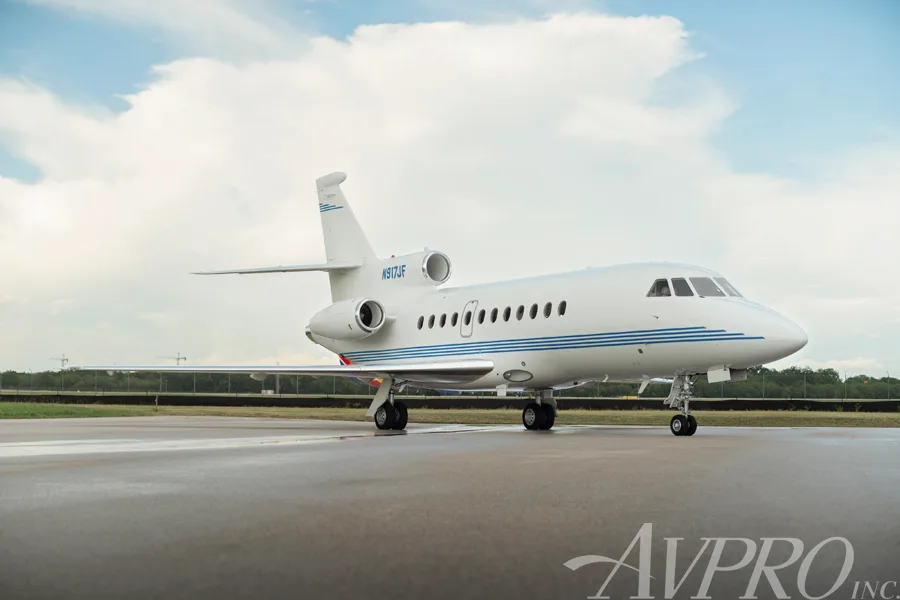 A Dassault Falcon 900EX, tail number N917JF, parked on a tarmac under a partly cloudy sky.