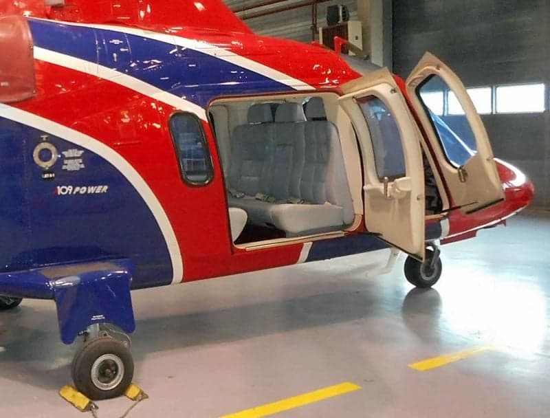 A red and blue helicopter parked on the tarmac.