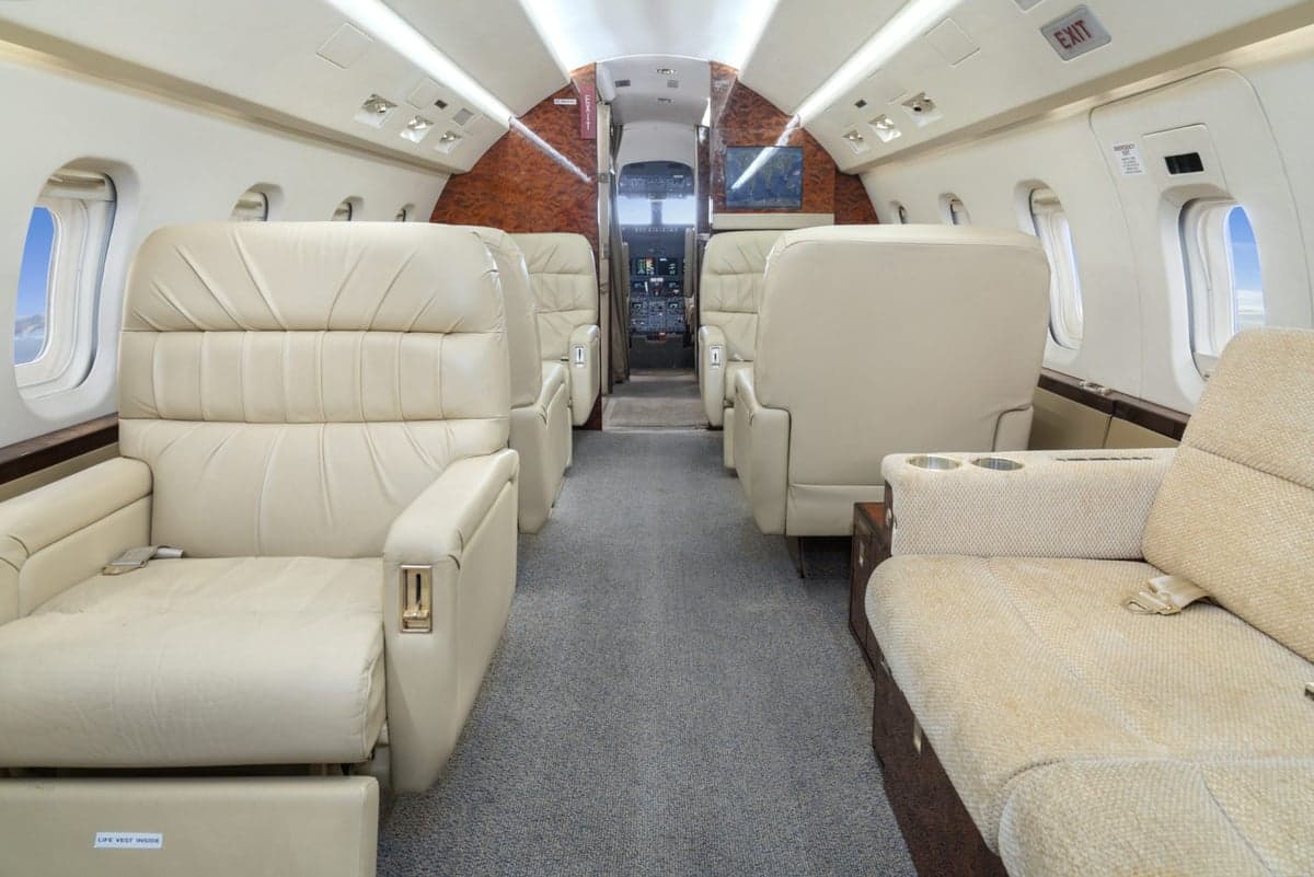 A view of the aircraft cabin with cream-colored leather seats.