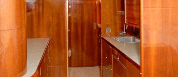 Galley area with wood cabinetry and sink.