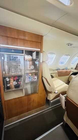 View of the interior of the aircraft, including a storage cabinet and leather seats.