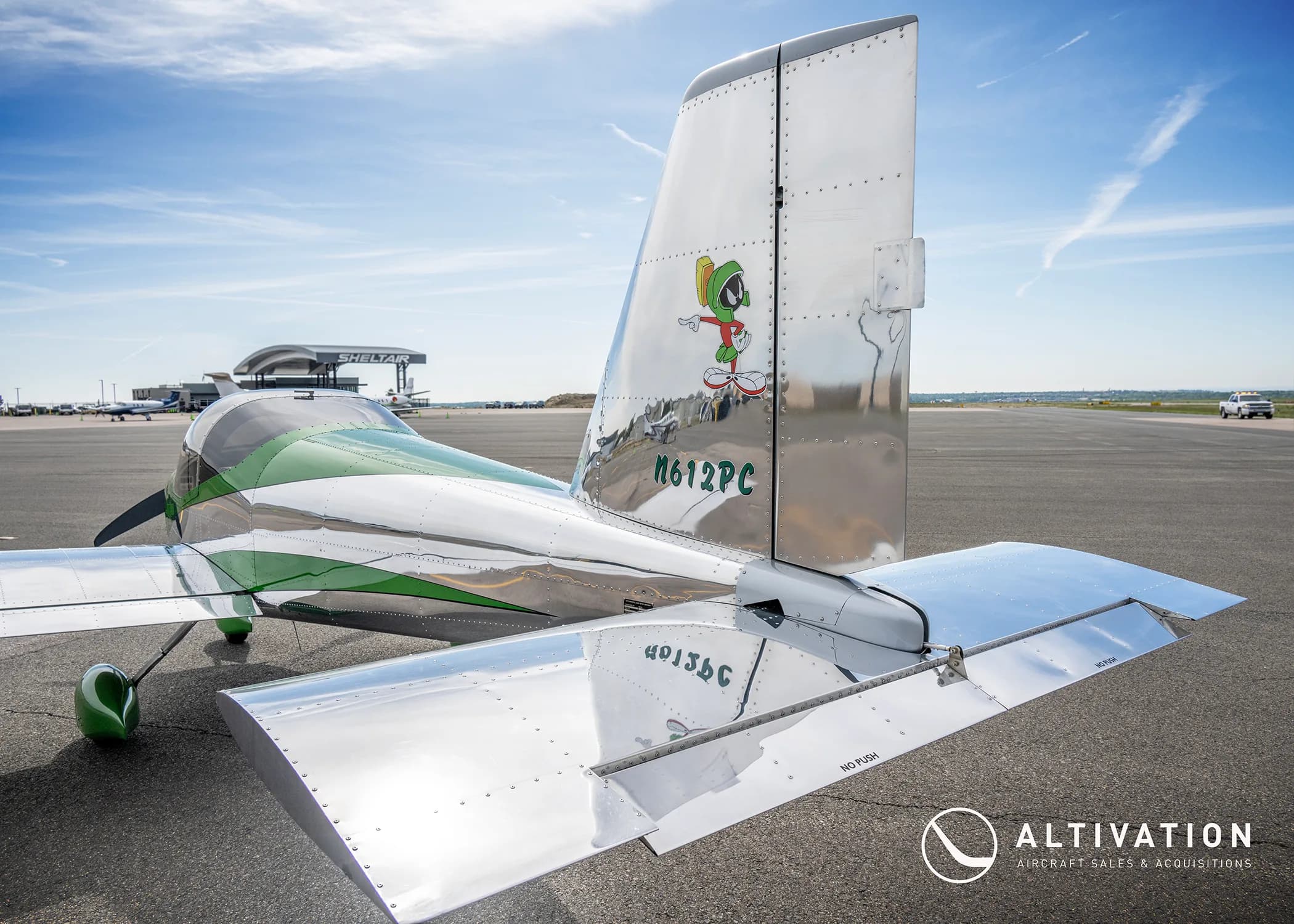 A close-up view of the polished aluminum tail of a Vans RV-12 aircraft, featuring a Marvin the Martian decal and registration N612PC.