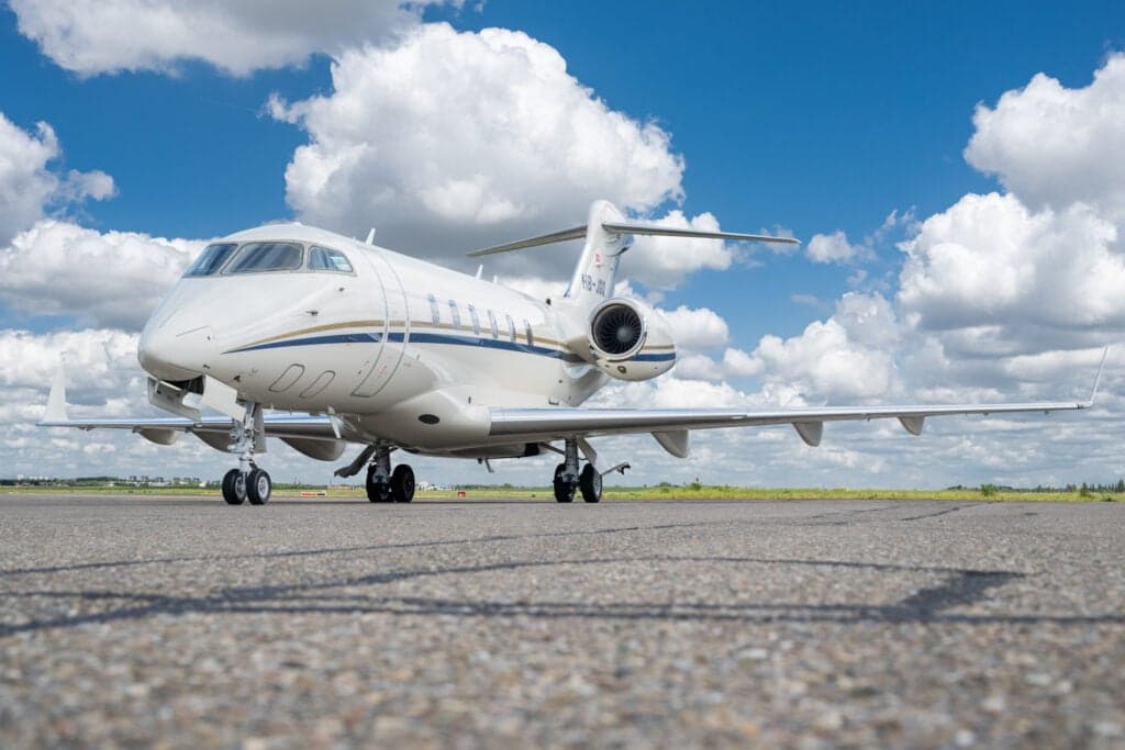 A Bombardier Challenger 350 aircraft is parked on the tarmac, viewed from the front quarter.
