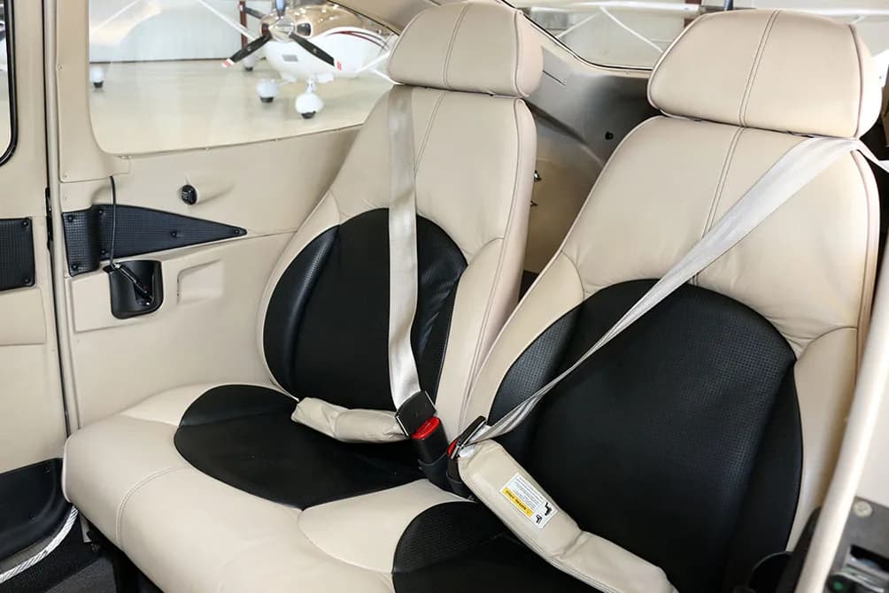 The tan and black leather front seats of the aircraft cabin are shown.