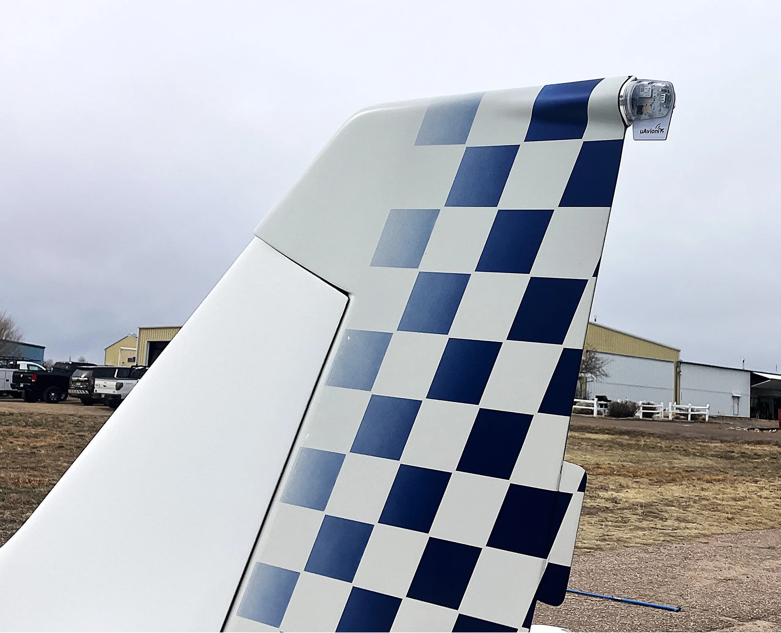 A close-up view of the white and blue checkered tail of the Glasair Sportsman aircraft.