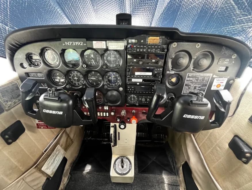 The cockpit instrument panel of a Cessna aircraft, showing gauges, radios, and controls, with N73192 visible on the panel.