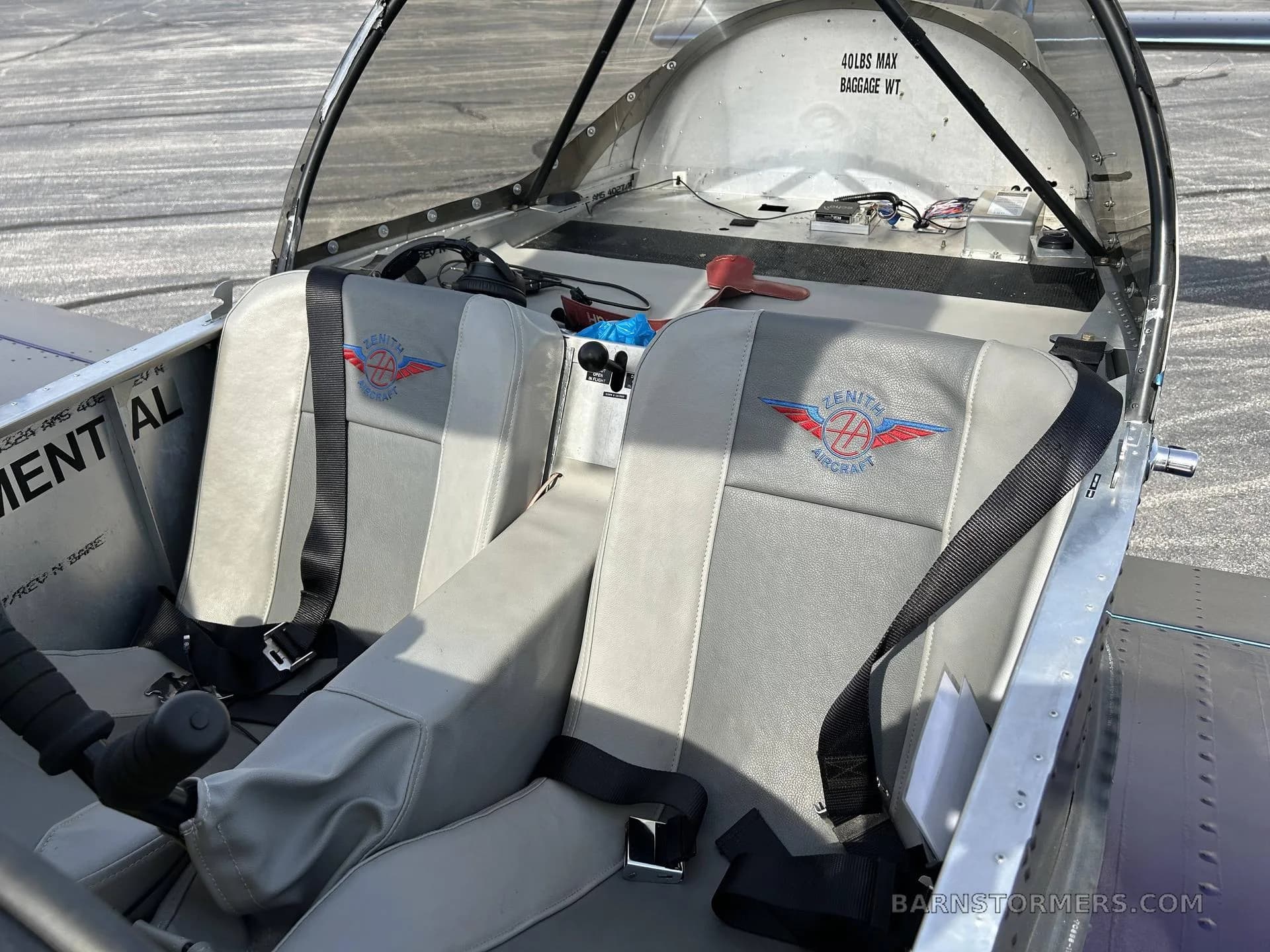 The interior of a Zenith aircraft showing two grey seats with Zenith Aircraft logos and a baggage weight limit.