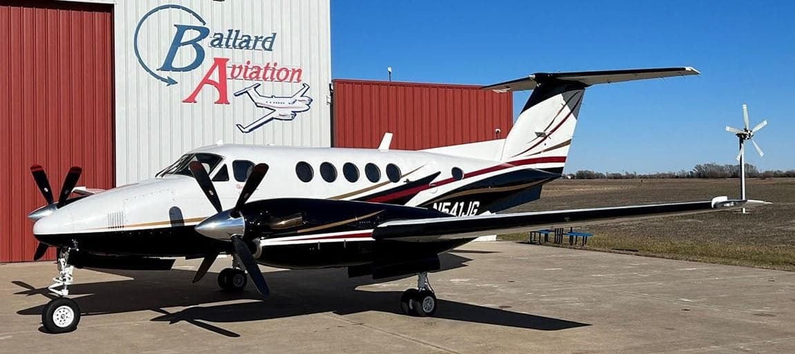 Beechcraft King Air N541JG parked in front of a hangar with the Ballard Aviation logo.