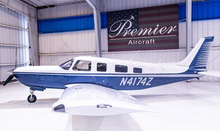 Piper PA-28-181 Archer II aircraft with blue and white paint scheme in a hangar, registration N4174Z.