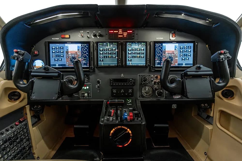 The cockpit of the N220MA aircraft, featuring multiple digital displays and dual yokes.