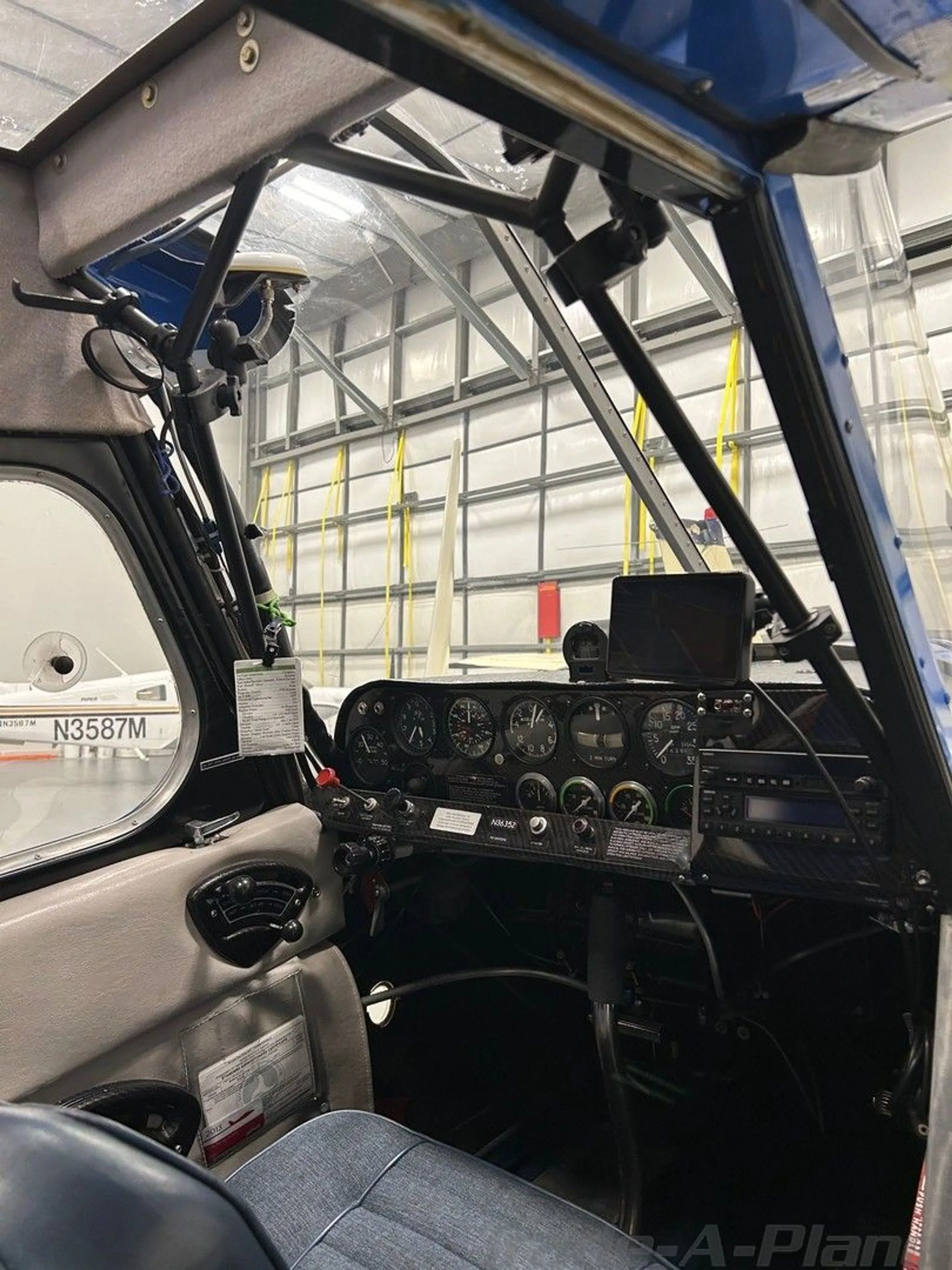 The cockpit interior of an aircraft, showing the instrument panel with gauges and controls.