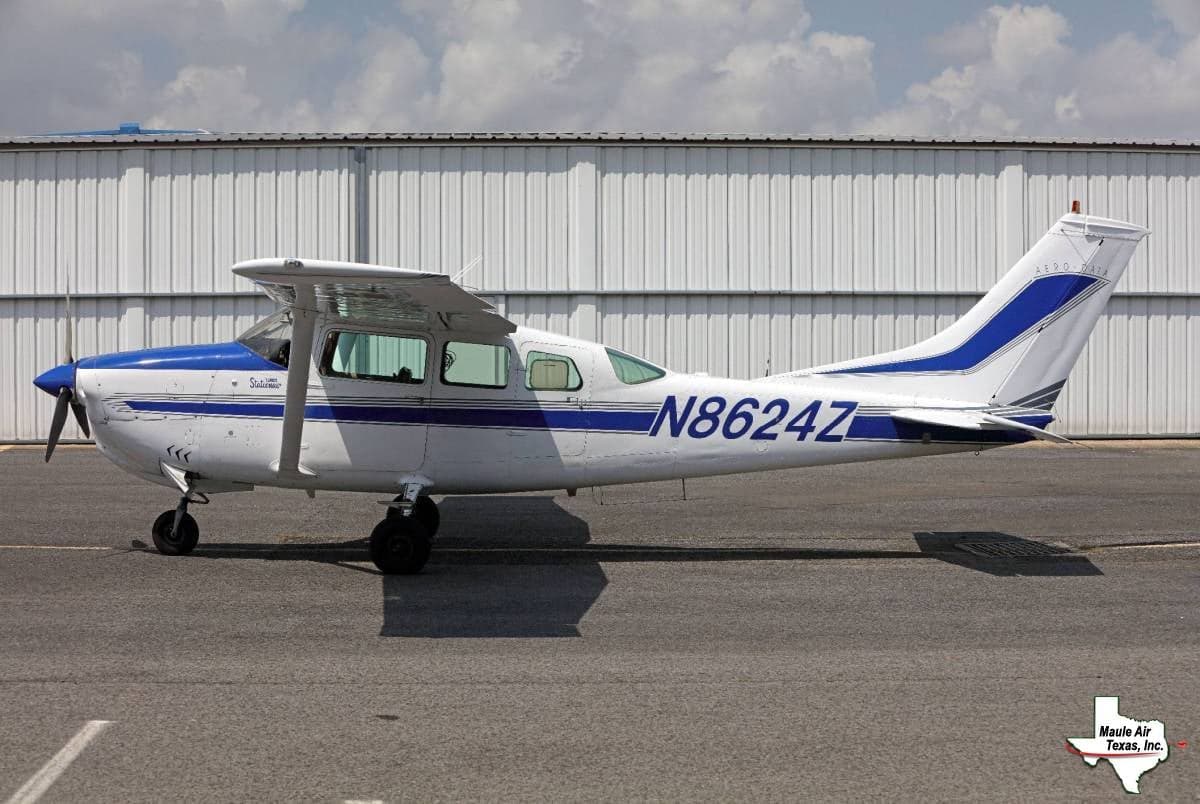 A white and blue Cessna 210 Centurion, registration N8624Z, is parked on the tarmac.