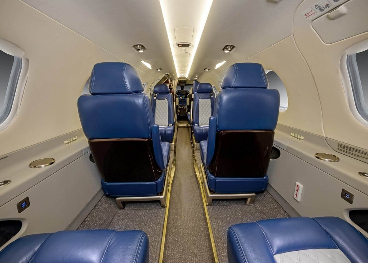 The interior of the aircraft, featuring blue leather seats.