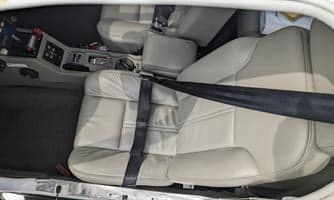 The interior of the aircraft shows the front seats with seatbelts.