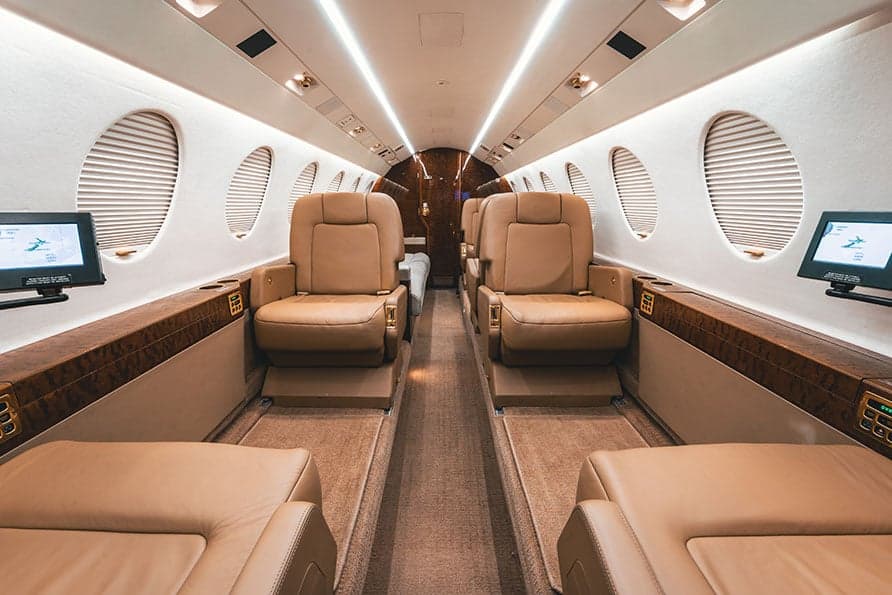 The Falcon 7X cabin features comfortable leather seating and entertainment screens.