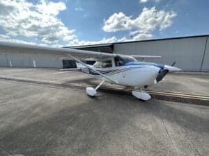 Cessna 172 Skyhawk, registration N759CB, parked on the tarmac in front of a hangar.