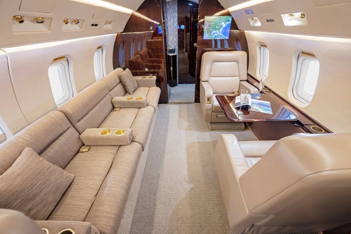 Interior view of the aircraft cabin with seating and tables.
