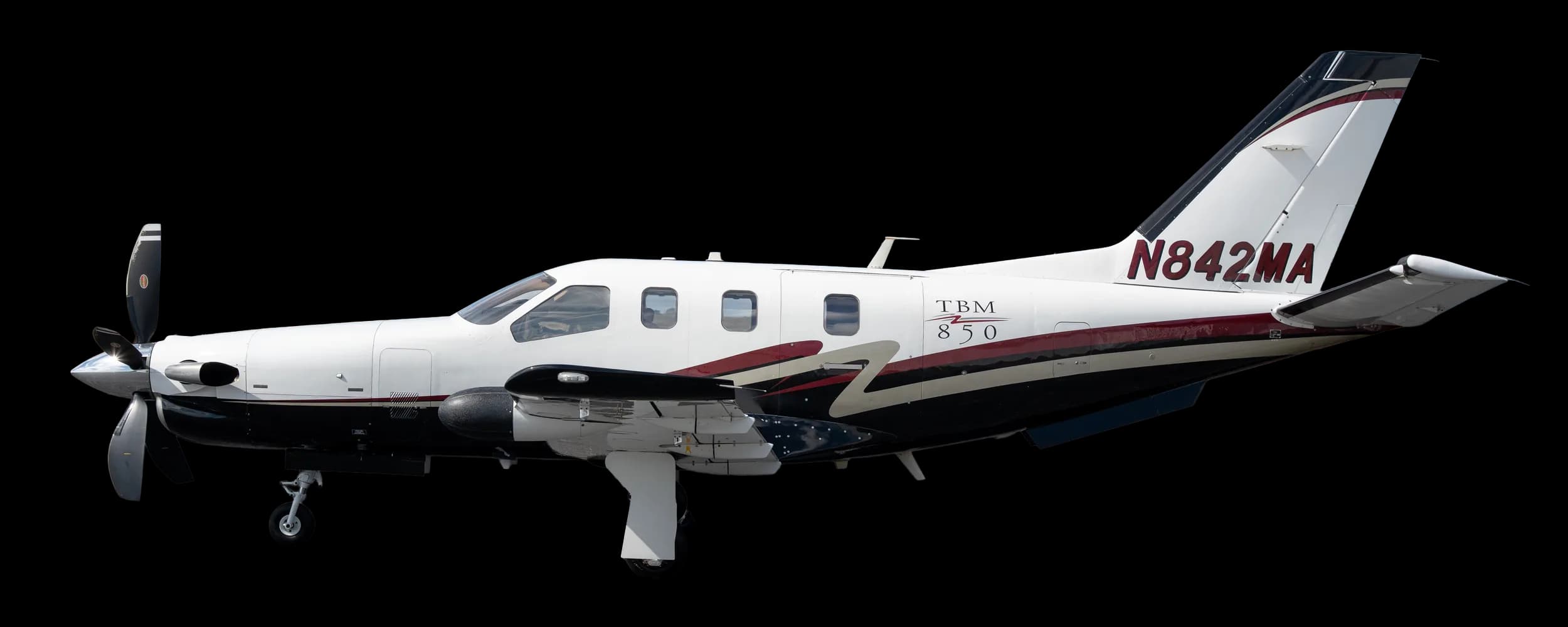 A white TBM 850 turboprop aircraft with black and red accent stripes, seen from the side against a clear sky.