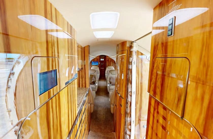 The interior of the Challenger aircraft features wood paneling and leather seats.