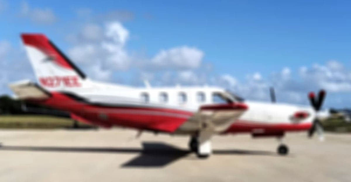 Blurred side view of the N271EE aircraft with a white and red paint scheme.