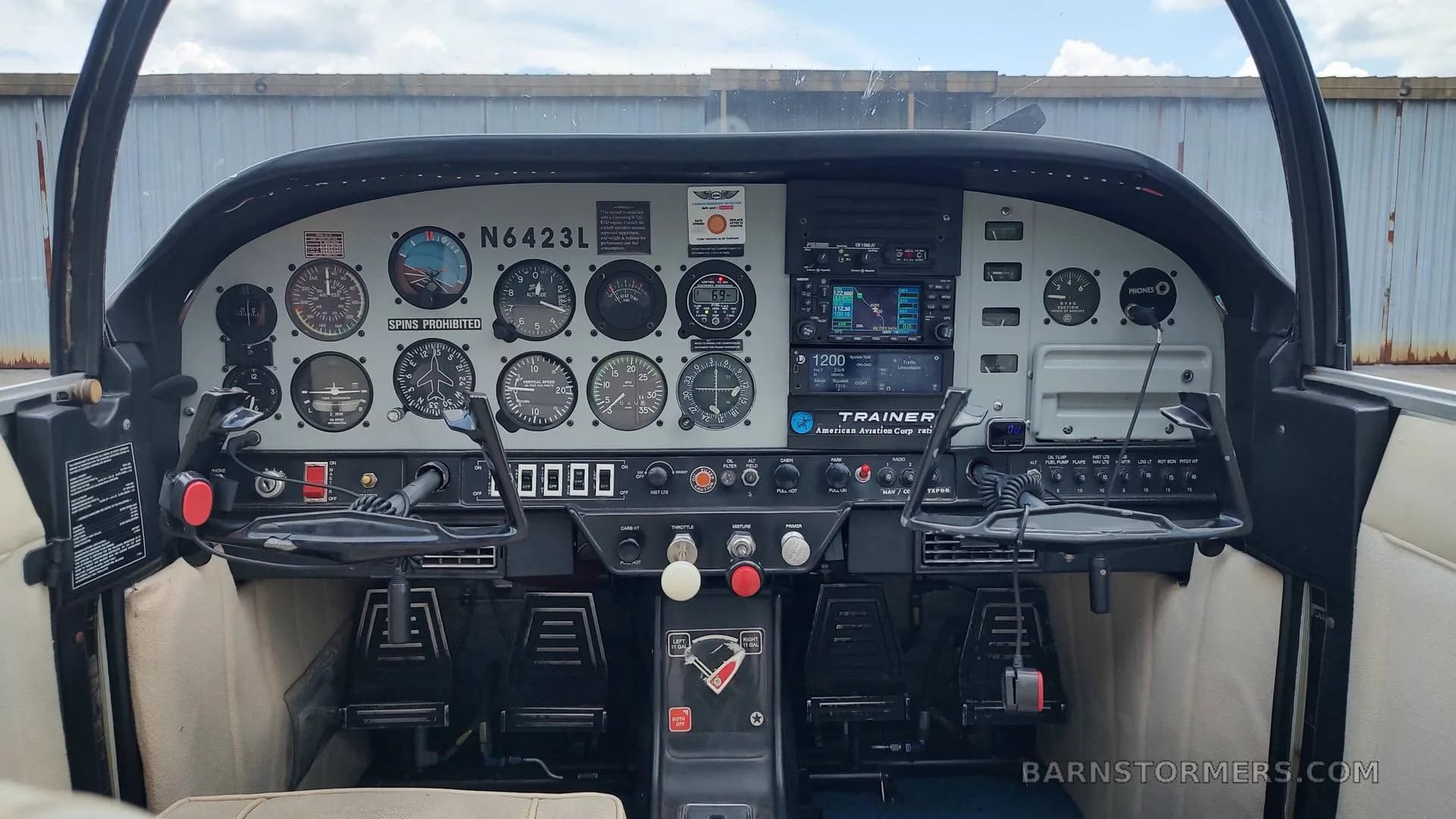 The cockpit of an American Aviation AA-1 Yankee aircraft, showing the instrument panel with gauges, radios, and controls.