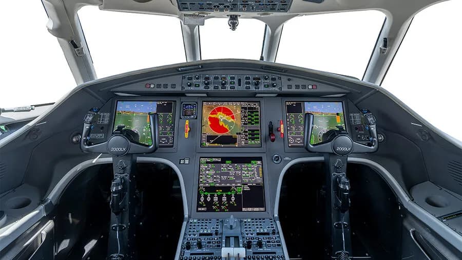 The modern cockpit of a Dassault Falcon 2000LX features multiple large digital displays and control yokes.