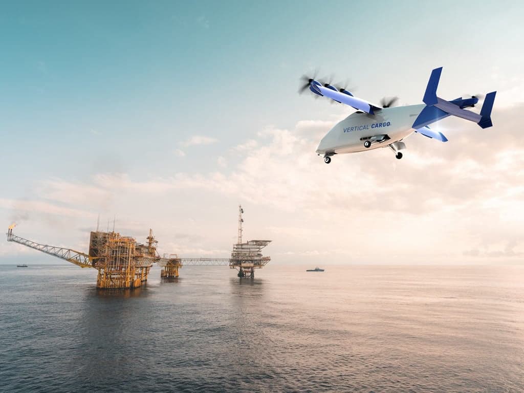 A Vertical Cargo aircraft flying over an oil rig.