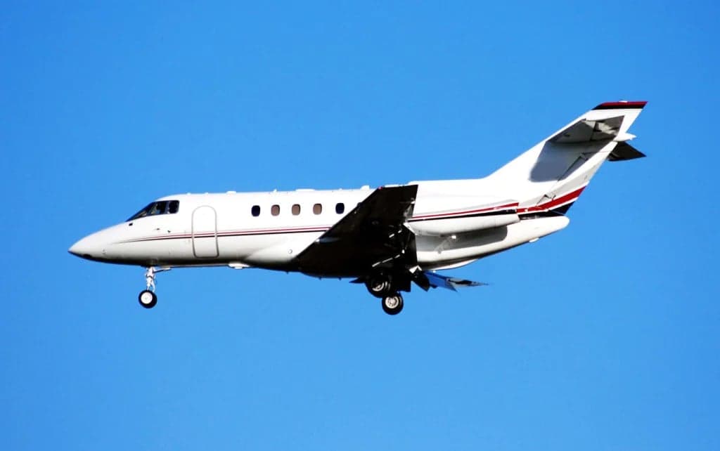 A Citation Latitude aircraft in flight against a clear blue sky.