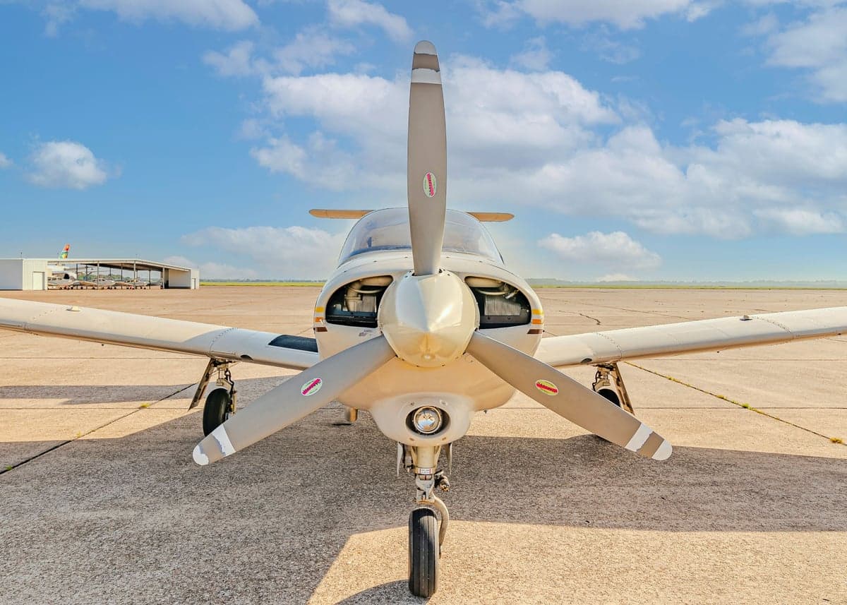 Front view of a Piper Arrow II with a tan and orange paint scheme.