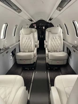 Interior view of the aircraft cabin with white leather seats.