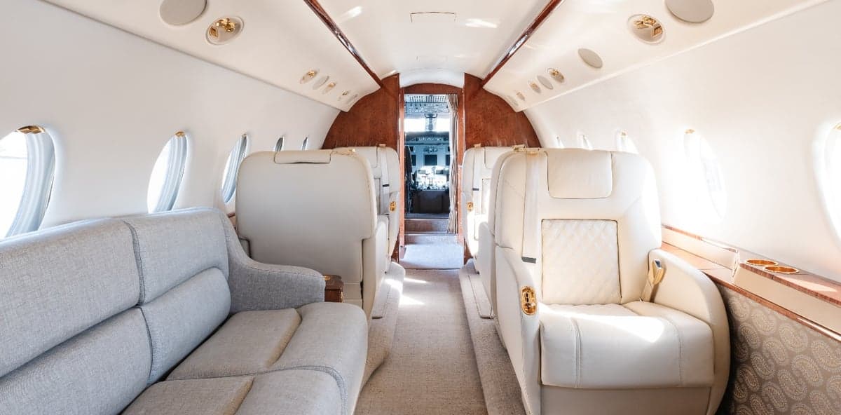 Interior view of the aircraft cabin showing the seating arrangement and cockpit.