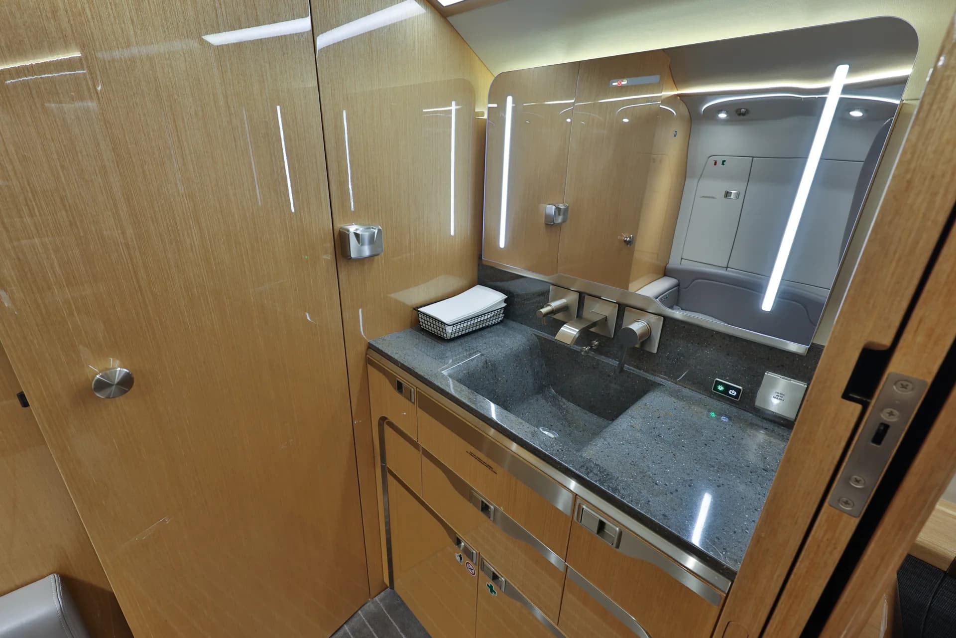 The lavatory of a Challenger aircraft with a sink and mirror.