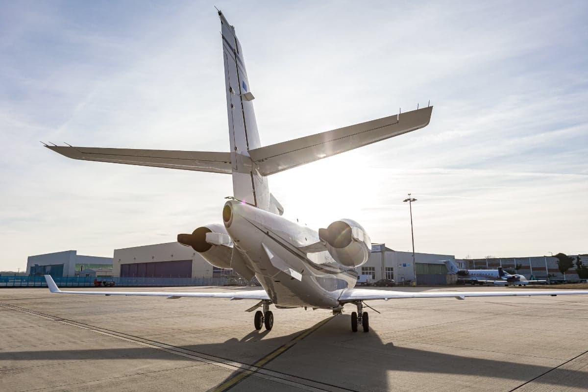 Rear view of a Gulfstream G200 aircraft with the tail number OK-GLX parked on the tarmac.