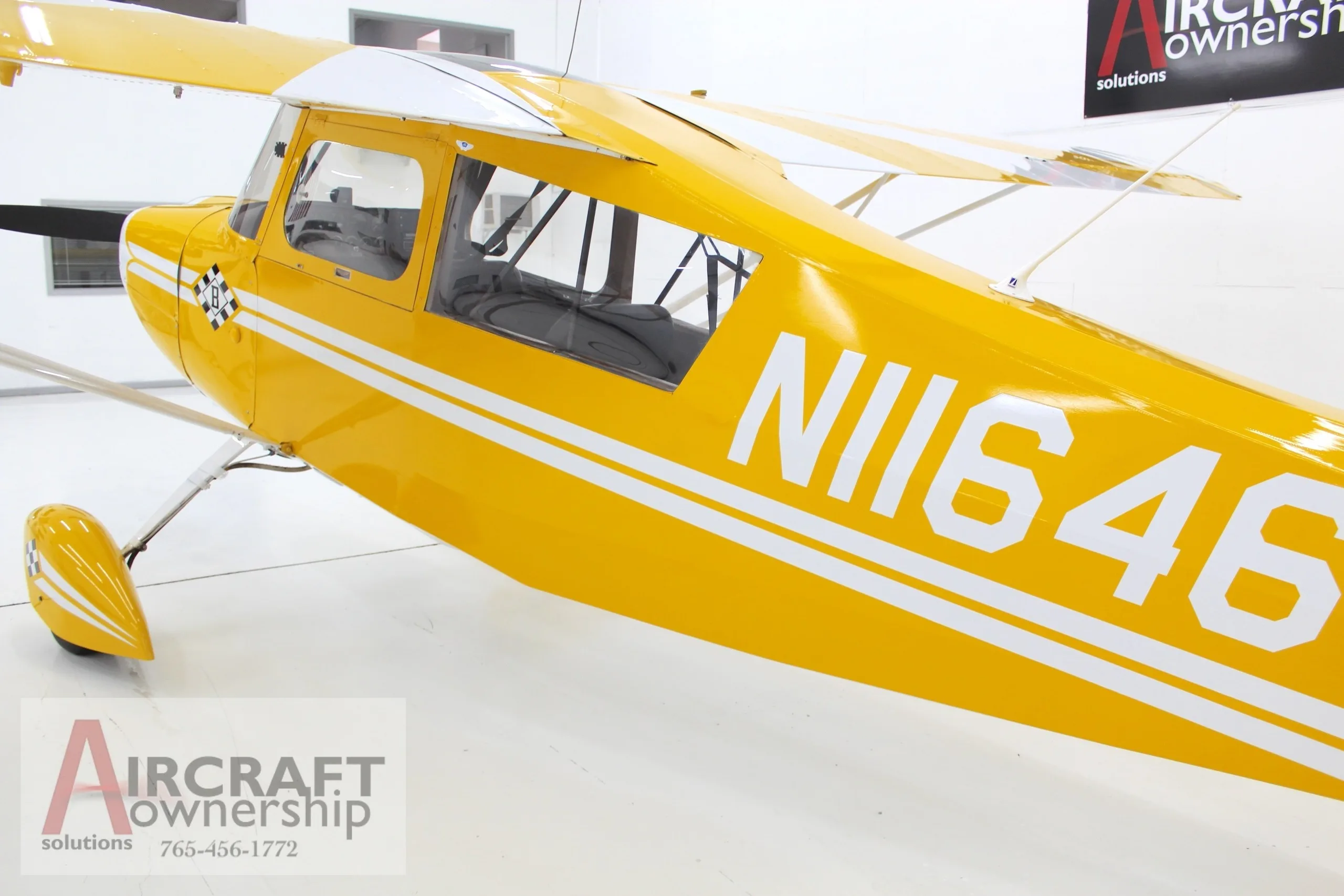 A rear-side view of the yellow and white N11646 aircraft, showing the registration number on the fuselage.