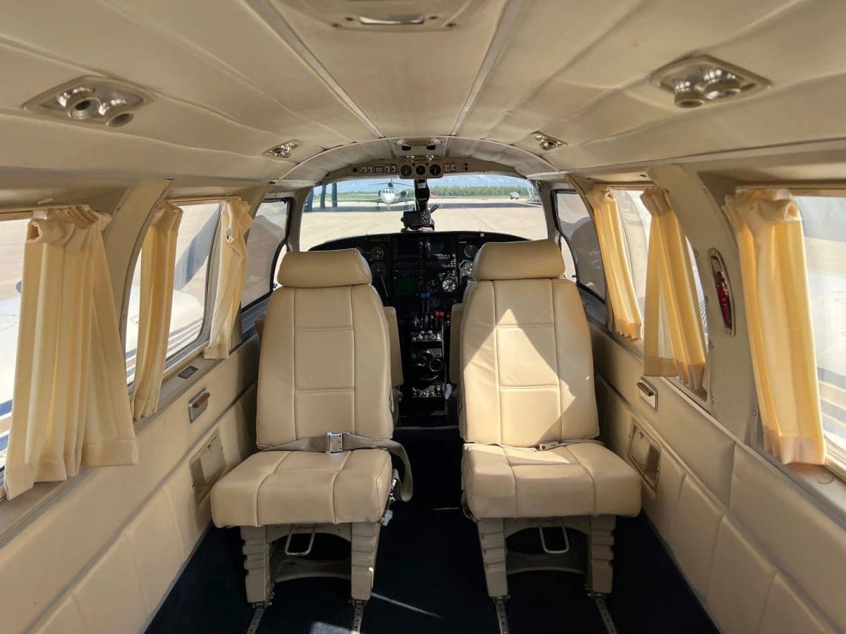 View of the aircraft's interior through the open door, showing the seats and steps.