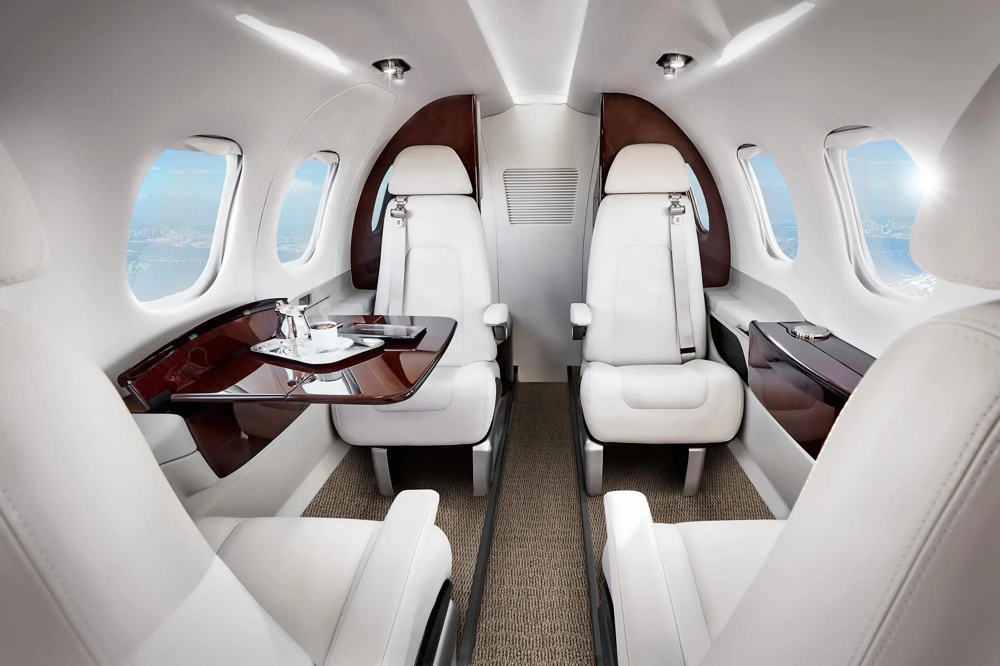 View of the interior cabin with white leather seats and wood accents.