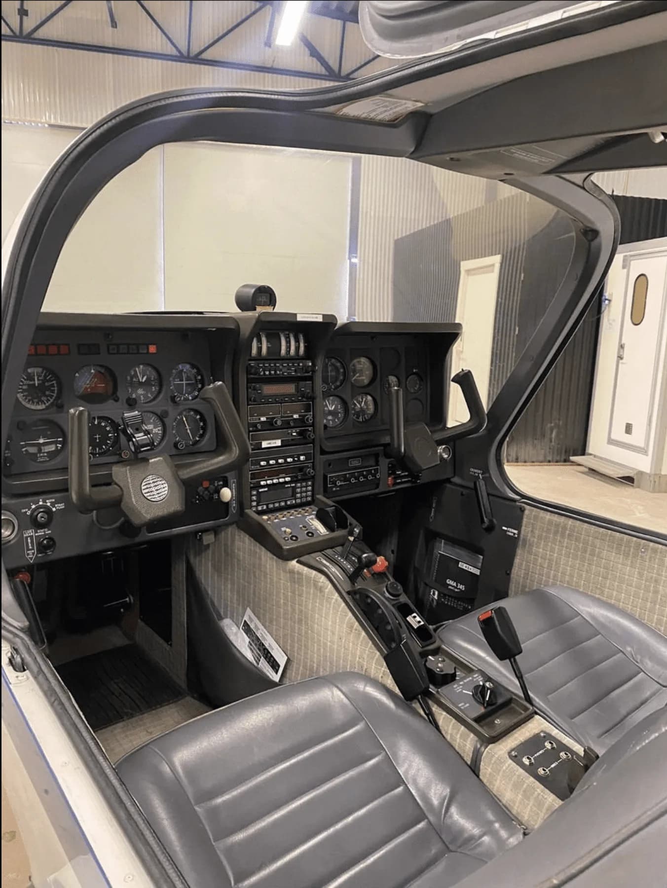 Interior view of the cockpit showing the instrument panel, yokes, and front seats of a Socata TB-20 Trinidad.