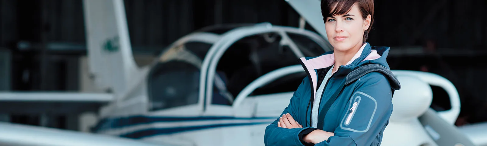 Woman standing in front of a Diamond DA40 aircraft in a hangar.