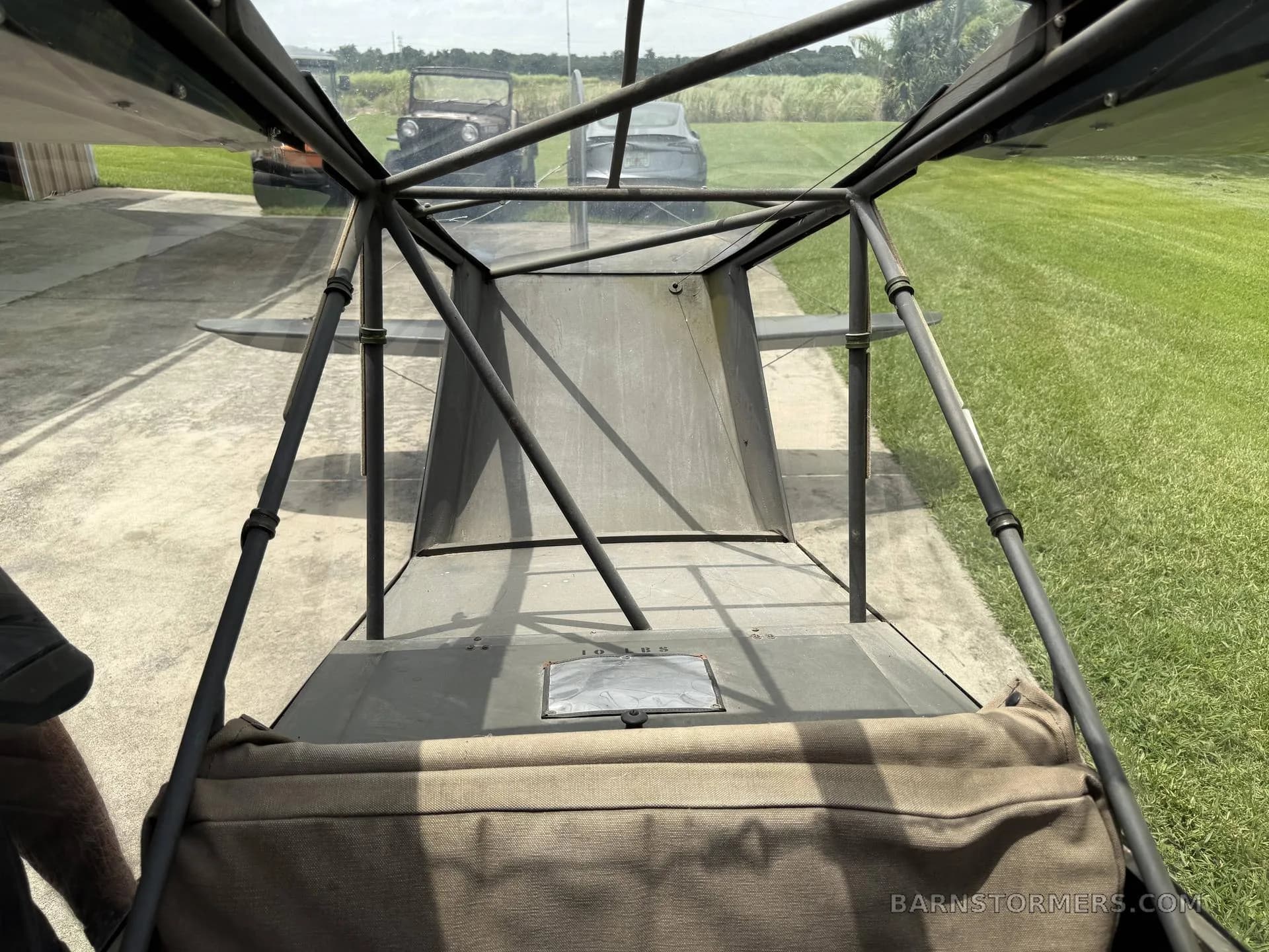 A view from inside the aircraft cabin looking towards the tail, showing the internal framework and a padded seat.