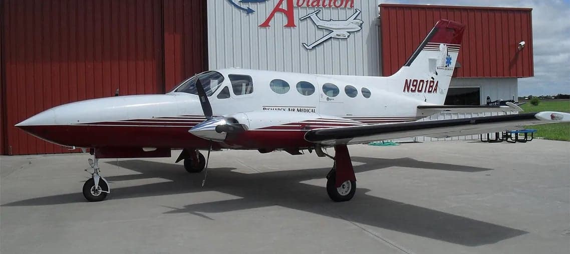 Aircraft N901BA, a white and maroon twin-engine plane, parked on the tarmac.