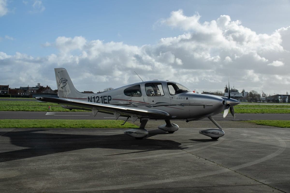 A Cirrus SR22T aircraft with registration N121EP is parked on the tarmac.
