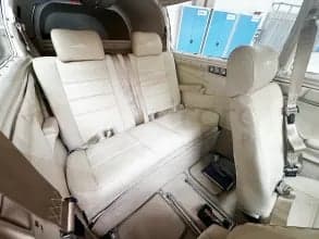 Rear interior view of the aircraft showing the cream-colored seats and seatbelts.