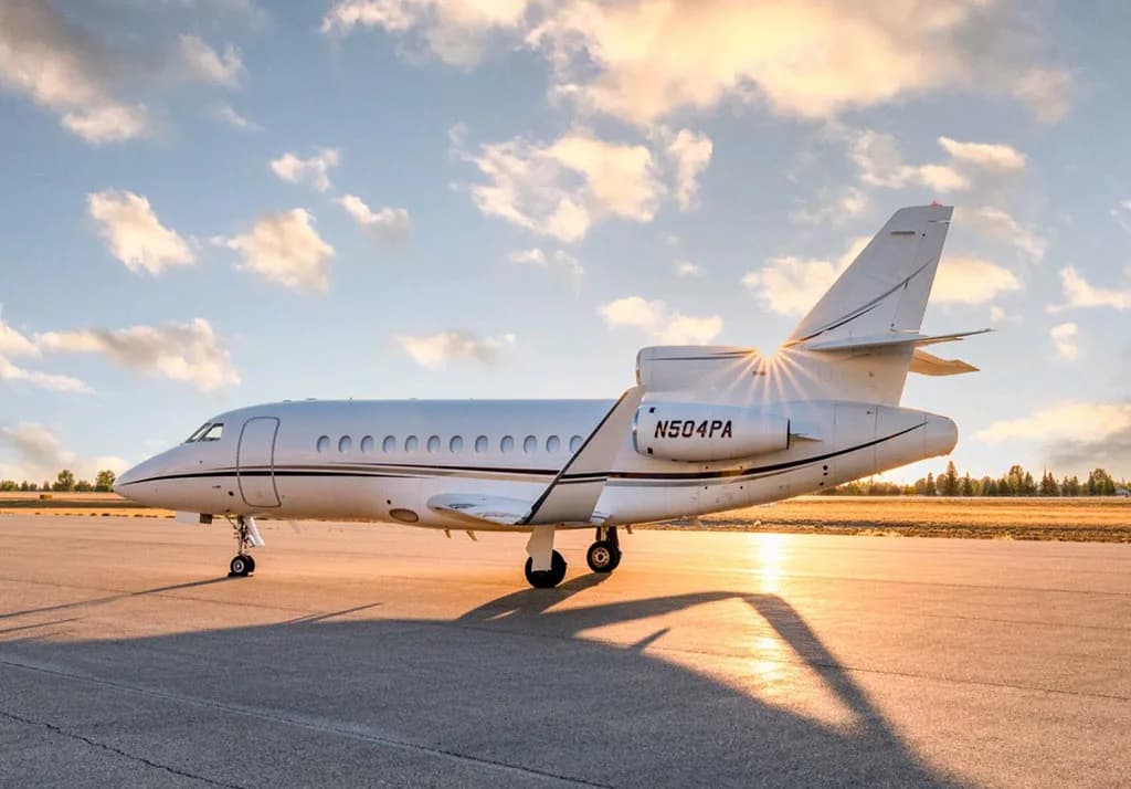 A Dassault Falcon 900EX business jet, registration N504PA, on the tarmac at sunset.