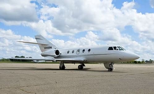 Side view of a Hawker jet with registration N998BM parked on the tarmac.
