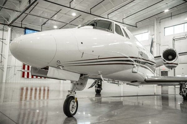 A close-up of the front of a Citation jet with a white and red paint scheme.